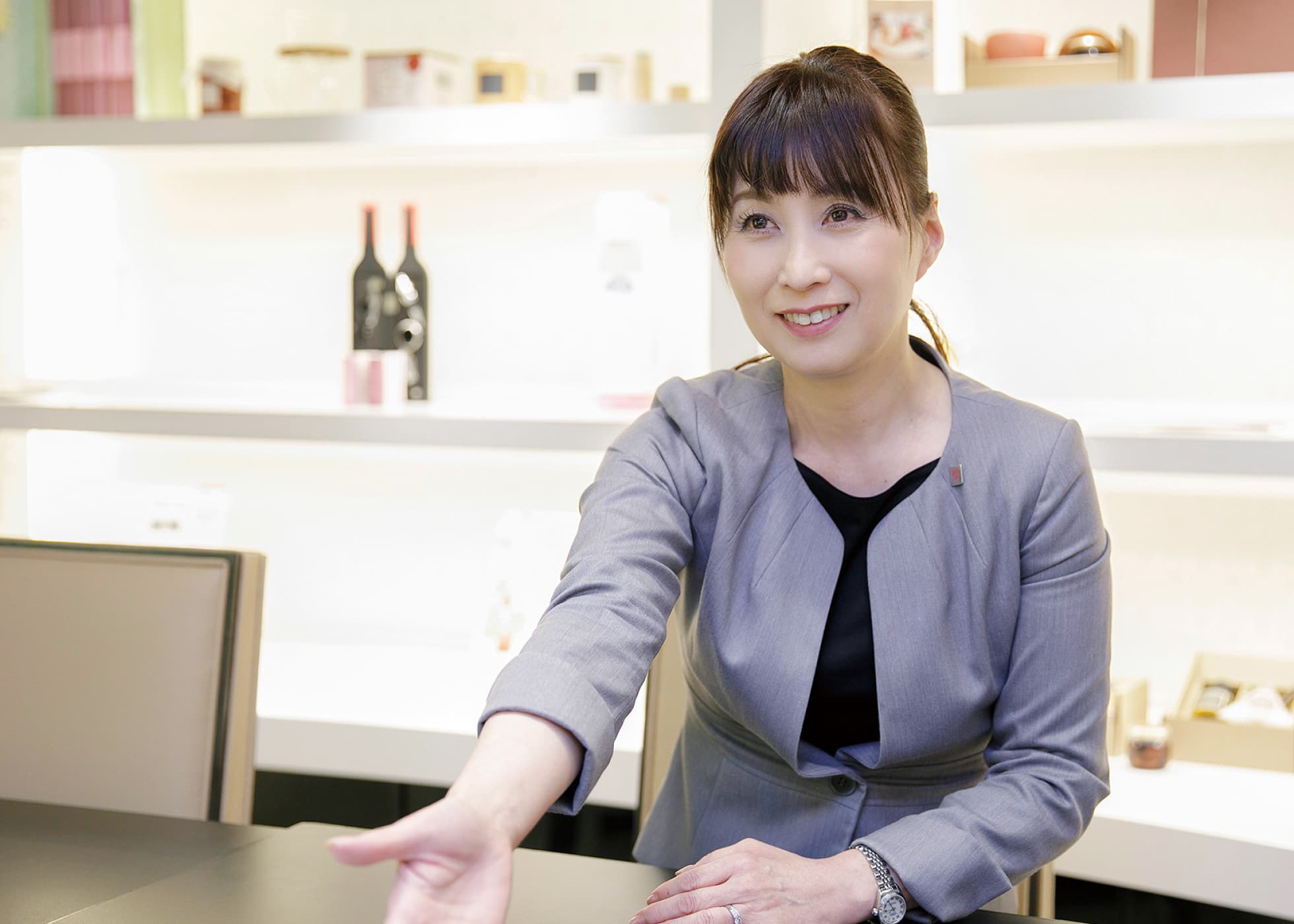 グレーのスーツで接客中の恋河内さん
